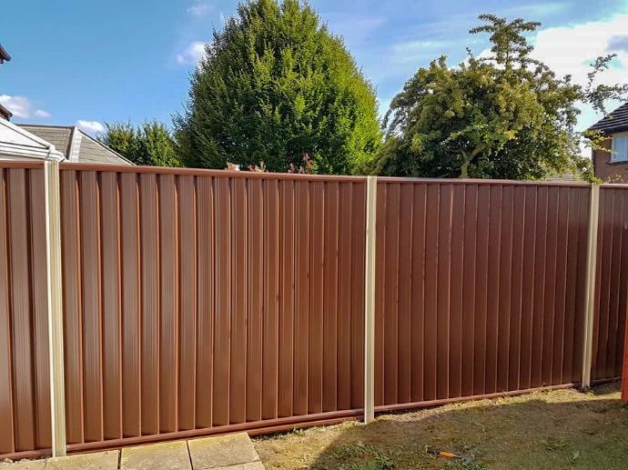 A grey steel fence behind an orange tree in a Costa del Sol garden