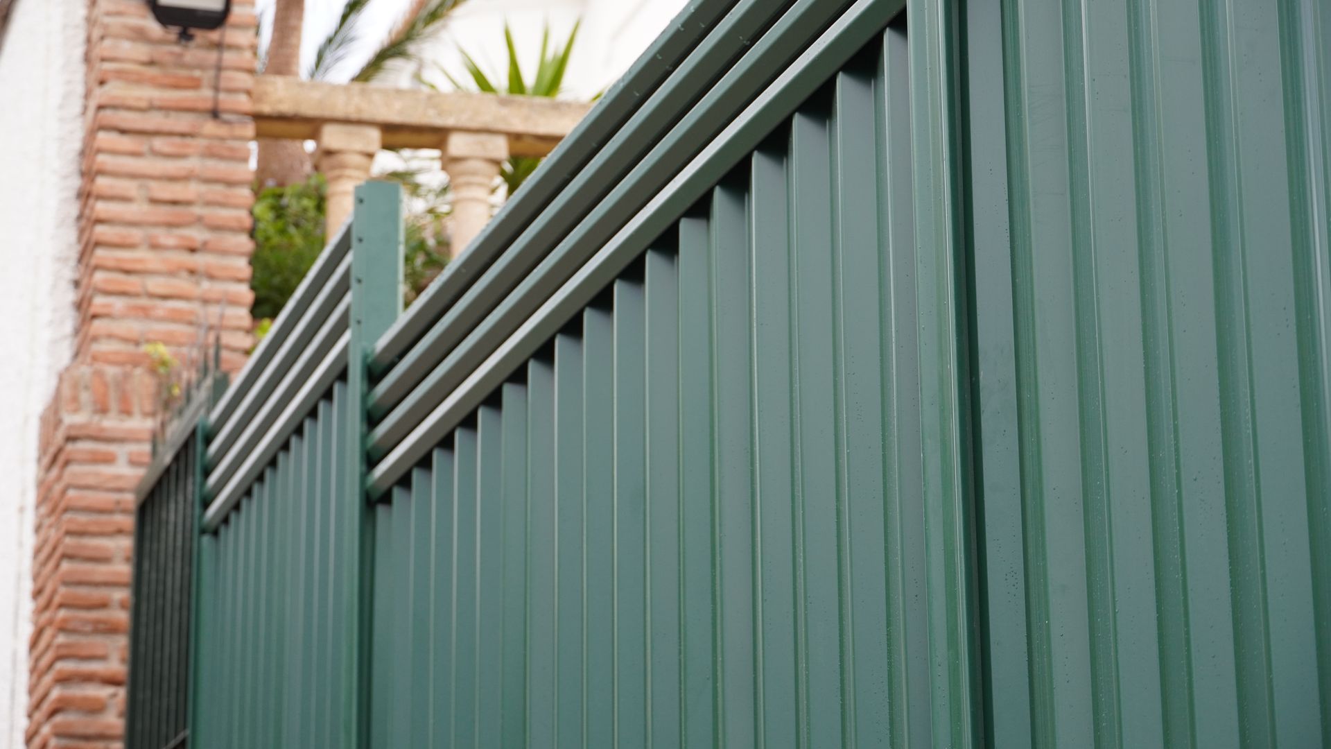 A green EasyFence steel fence with a slatted top, put up at a house on the Costa del Sol